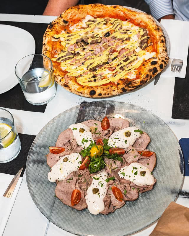 Pizza and vitello tonnato on a table at the restaurant